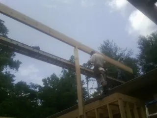 Carpenter setting a ridge beam over a new addition frame — Ice Dam Removal by Roofing Brothers in Atlantic City